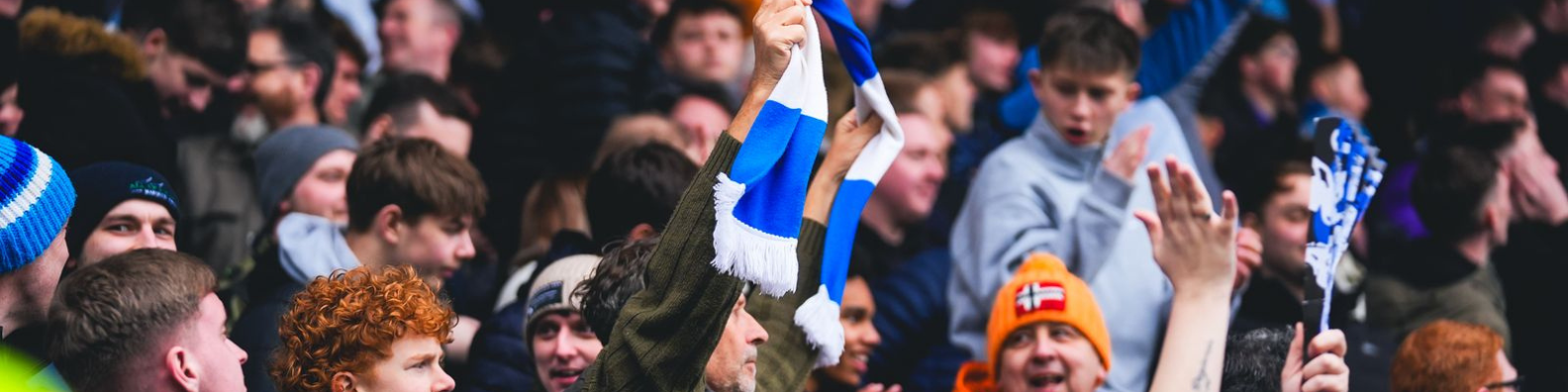 Man holding Huddersfield Town FC scarf in crowd